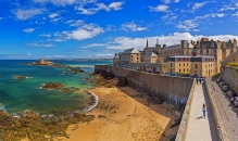 Historische Festung an der Küste mit Sandstrand und blauem Himmel.