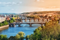 Stadtansicht mit Brücken über einen Fluss bei Sonnenuntergang.