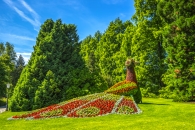 Pfauenförmige Blumeninstallation in einem grünen Park.