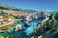 Blick auf die Altstadt von Dubrovnik mit Stadtmauern und türkisblauem Meer.