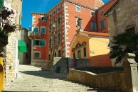 Blick auf eine farbenfrohe, historische Gebäudeansicht in einer schmalen Gasse in Labin, Istrien.