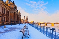 Verschneite Uferpromenade in Dresden mit Blick auf die historische Altstadt.