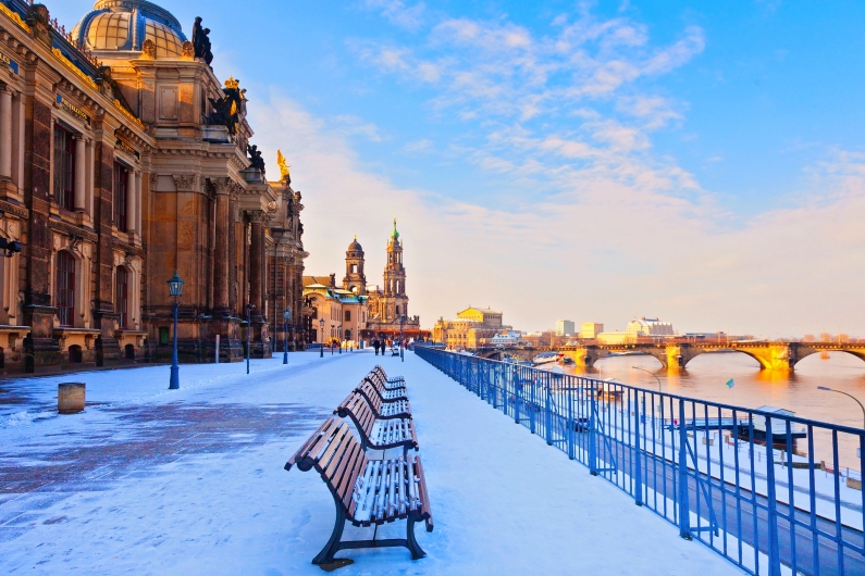 Verschneite Uferpromenade in Dresden mit Blick auf die historische Altstadt.