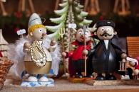 Holzfiguren von Engeln und Figuren in Weihnachtskostümen auf einem Markt.