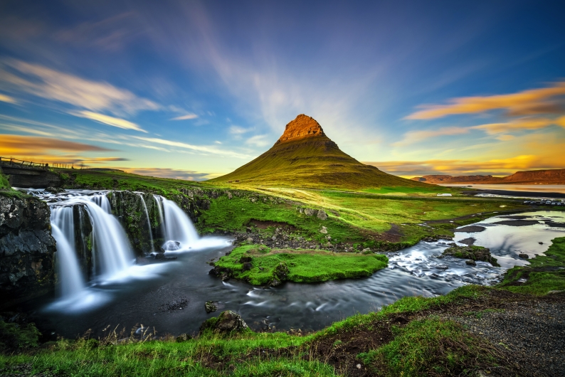 Berg mit Wasserfall und Fluss bei Sonnenuntergang, Kirkjufell, Island.