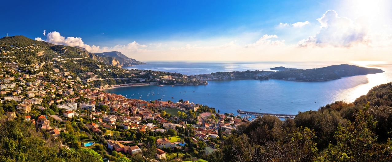 Küstenlandschaft mit Stadt und Bucht bei Sonnenschein.