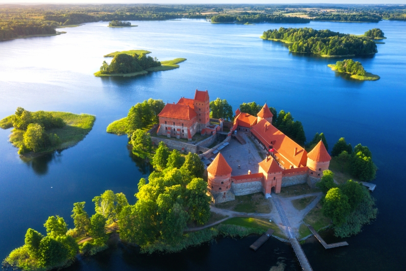 Luftaufnahme der Wasserburg Trakai in Vilnius, Litauen, umgeben von einem See und grünen Inseln.