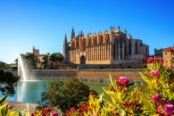 Kathedrale von Palma de Mallorca mit einer blühenden Umgebung und einem See im Vordergrund.