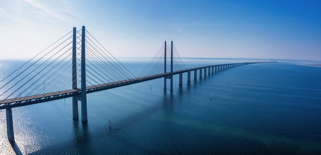 Lange Brücke über das Meer unter blauem Himmel.