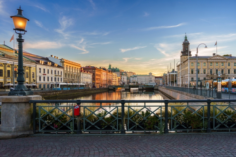 Städtischer Kanal mit Brücke und historischen Gebäuden bei Sonnenuntergang.