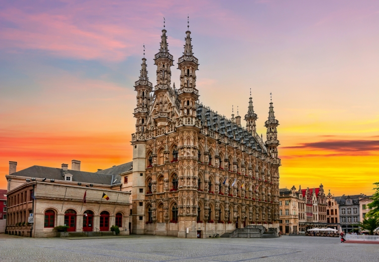 Historisches Gebäude vor buntem Sonnenuntergangshimmel.