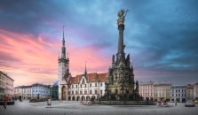 Historischer Platz mit einer Säule und alten Gebäuden bei Sonnenuntergang.
