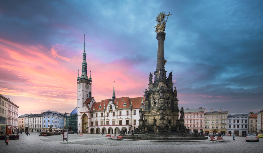 Historischer Platz mit einer Säule und alten Gebäuden bei Sonnenuntergang.