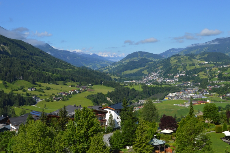 Landschaftsansicht eines grünen Tals mit Bergen im Hintergrund bei klarem Himmel.