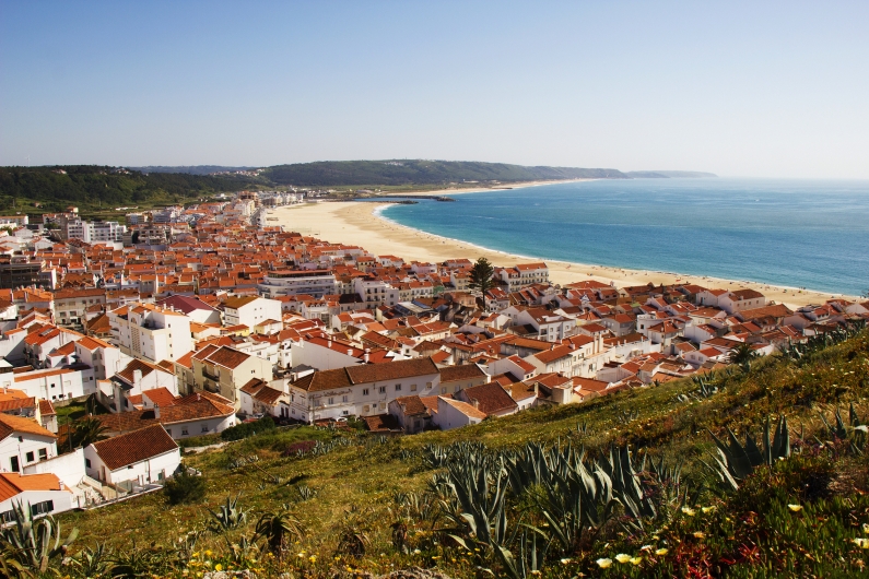 Aussicht auf eine Küstenstadt mit Strand und Meer unter klarem Himmel.