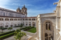 Klosterhof mit architektonischen Details und gepflegten Gärten unter blauem Himmel
