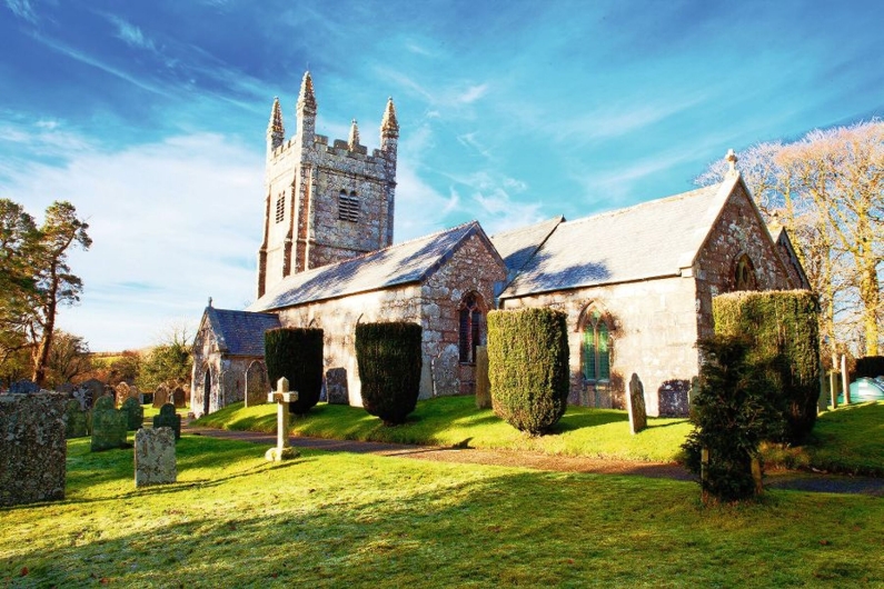 Historische Kirche mit Friedhof im Sonnenschein.