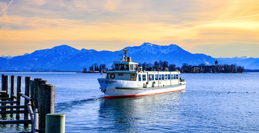 Ein Boot auf einem See mit schneebedeckten Bergen im Hintergrund.