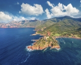 blaues Meer und kleines Dorf an Küstenzipfel