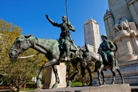 Bronzestatue von zwei Reitern in einem städtischen Park.