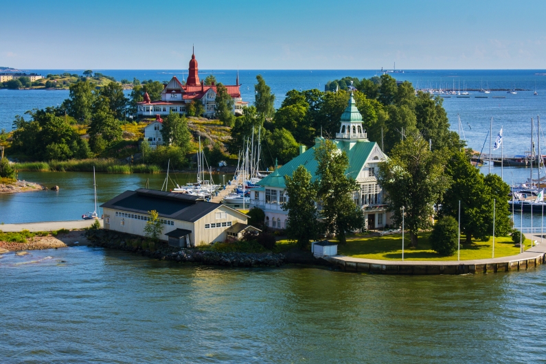Inseln im Archipel von Helsinki in Finnland mit Booten und historischen Gebäuden im Hintergrund.