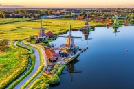 Historische Windmühlen an einem Fluss bei Sonnenuntergang.