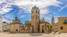 Historische Kathedrale auf einem Stadtplatz bei blauem Himmel.