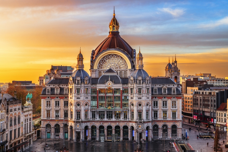 Belgisches Stadtbild mit dem Hauptbahnhof von Antwerpen bei Sonnenuntergang.