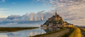 Kloster Mont-Saint-Michel auf einer felsigen Insel bei Sonnenuntergang.