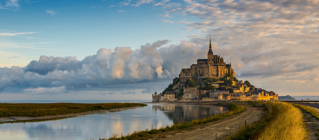 Kloster Mont-Saint-Michel auf einer felsigen Insel bei Sonnenuntergang.