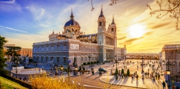 Kathedrale Almudena in Madrid bei Sonnenuntergang, mit Menschen auf dem Platz davor.