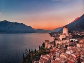 Luftaufnahme von Malcesine am Gardasee bei Sonnenuntergang mit Burg und Bergen.