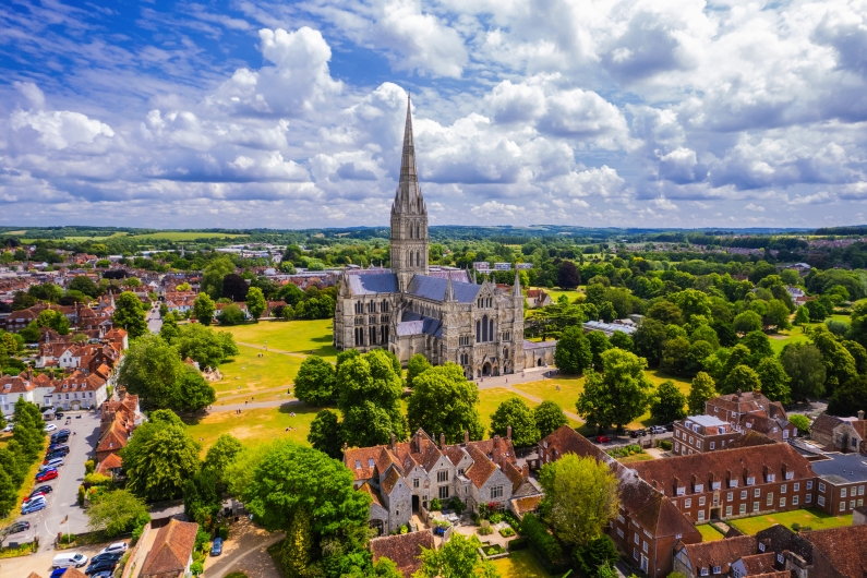 Luftaufnahme einer großen Kathedrale mit einem hohen Turm und umgebender Landschaft