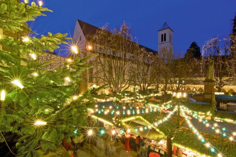 Weihnachtsmarkt mit Lichtern und Dekorationen in der Abenddämmerung.