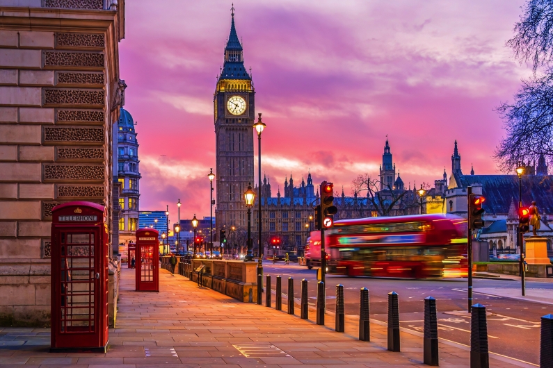 Big Ben und ein roter Bus bei Sonnenuntergang in London.