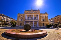 Historisches Gebäude mit Brunnen und Kugel in sonniger Umgebung.