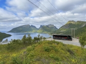 Grüne bergige Landschaft und eine Bucht mit Bus auf einem Aussichtspunkt