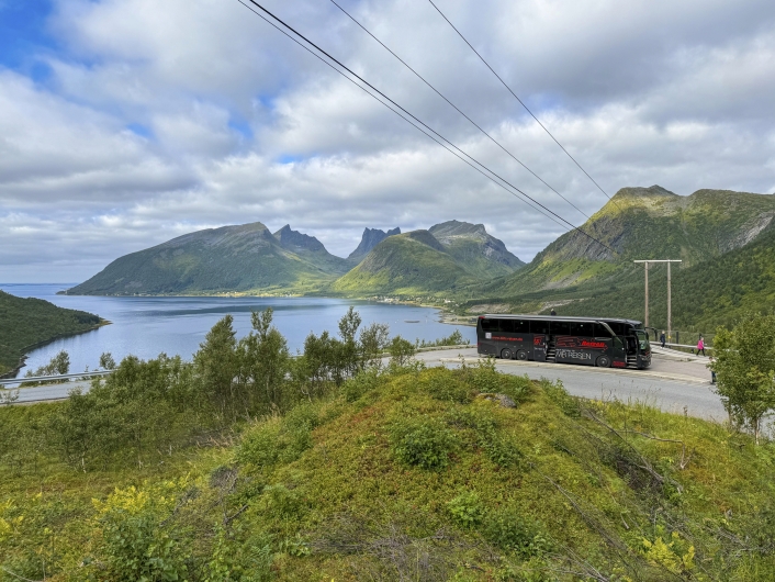 Grüne bergige Landschaft und eine Bucht mit Bus auf einem Aussichtspunkt