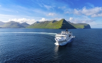 Schiff auf Meer vor grüner Insel