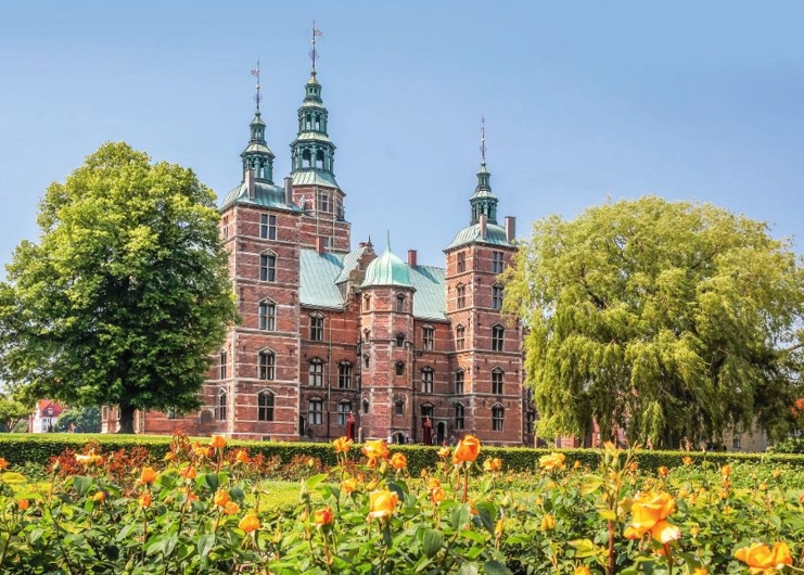 Schloss mit Türmen und Orangengarten im Vordergrund.