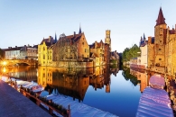 Historische Gebäude am Wasser bei Dämmerung in Brügge, Belgien.