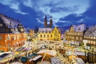Verschneiter Weihnachtsmarkt in einer historischen Altstadt am Abend.