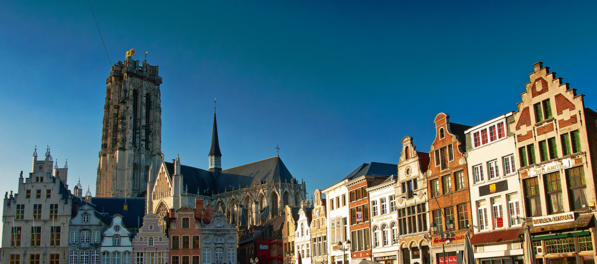 Historische Gebäude und ein Kirchturm unter klarem blauem Himmel.