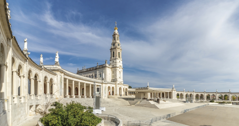 Weiße Gebäude an einem großen Platz unter blauem Himmel