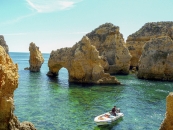 Orange Felsformationen mit Löchern im blaugrünen Meer