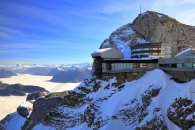 Gebirgsstation mit Schneebedeckung und Bergpanorama im Hintergrund.