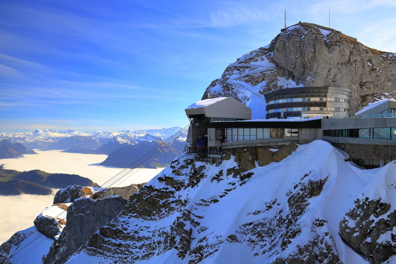 Gebirgsstation mit Schneebedeckung und Bergpanorama im Hintergrund.