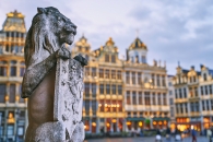 Löwenstatue auf einem Platz mit historischen Gebäuden im Hintergrund