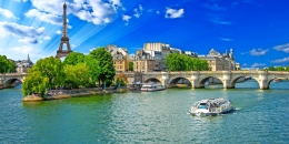 Fluss mit Brücke und Eiffelturm im Hintergrund bei klarem Himmel