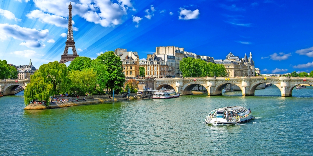 Fluss mit Brücke und Eiffelturm im Hintergrund bei klarem Himmel